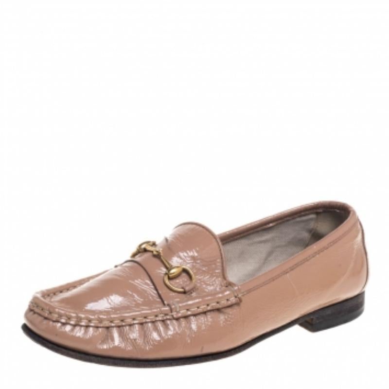 Project an ultra-stylish look in these beige loafers from Gucci! They have been crafted from patent leather and designed with round toes and the signature Horsebit accents on the vamps. They are complete with comfortable insoles and durable outsoles.