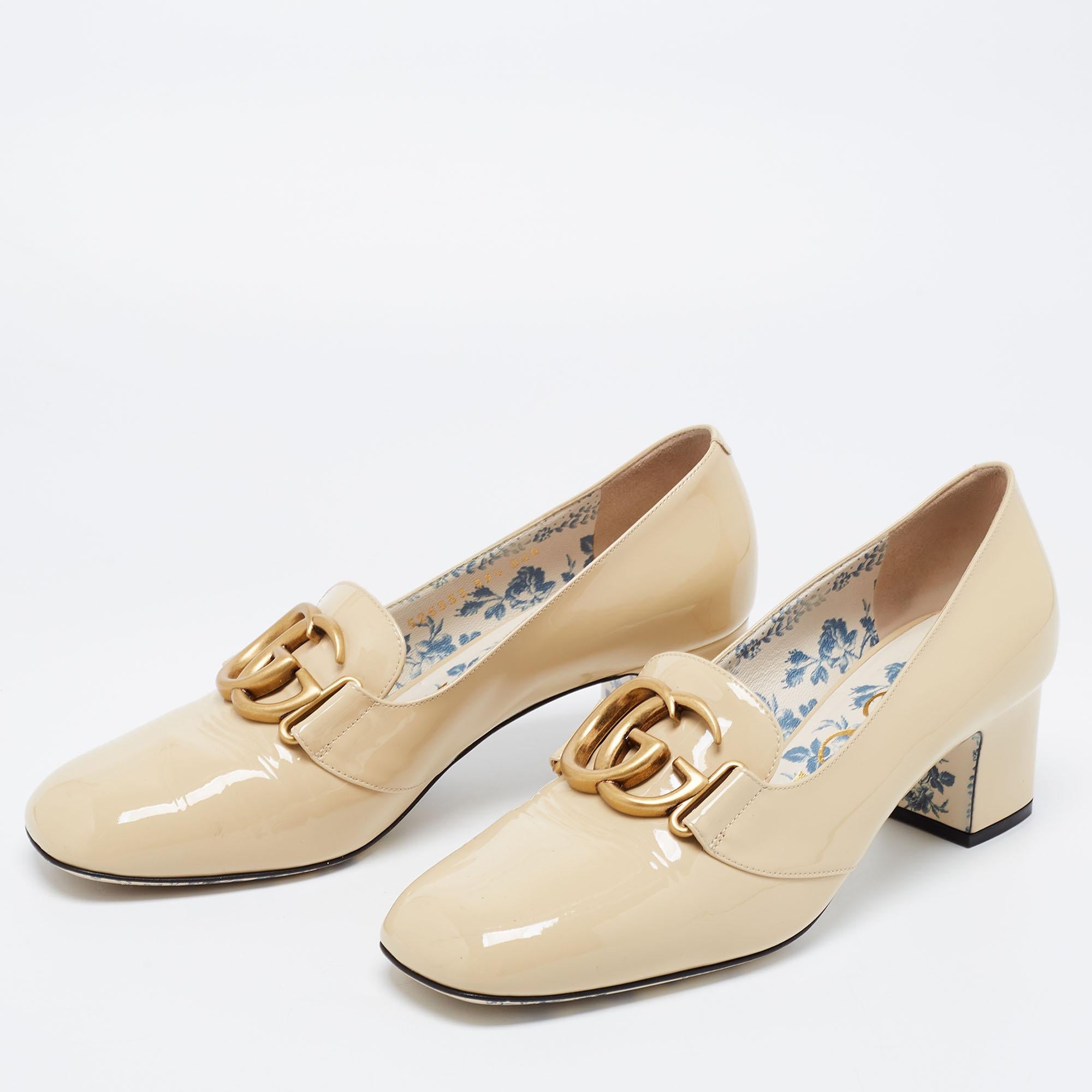 Gucci brings its signatory aesthetic into the limelight with these gorgeous Victoire pumps. Draped in beige patent leather, a gold-toned GG motif is placed atop the vamps for an iconic touch. They are complemented with block heels, a slip-on