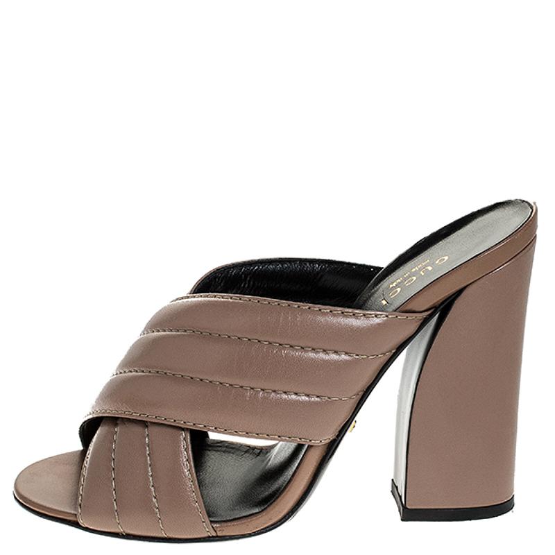 Mules are a raging trend these days. Hurry and join the style wave today with these mules from Gucci. Crafted from leather in a sleek beige shade, they have been styled with two crossover straps and block heels. The insoles have also been lined with