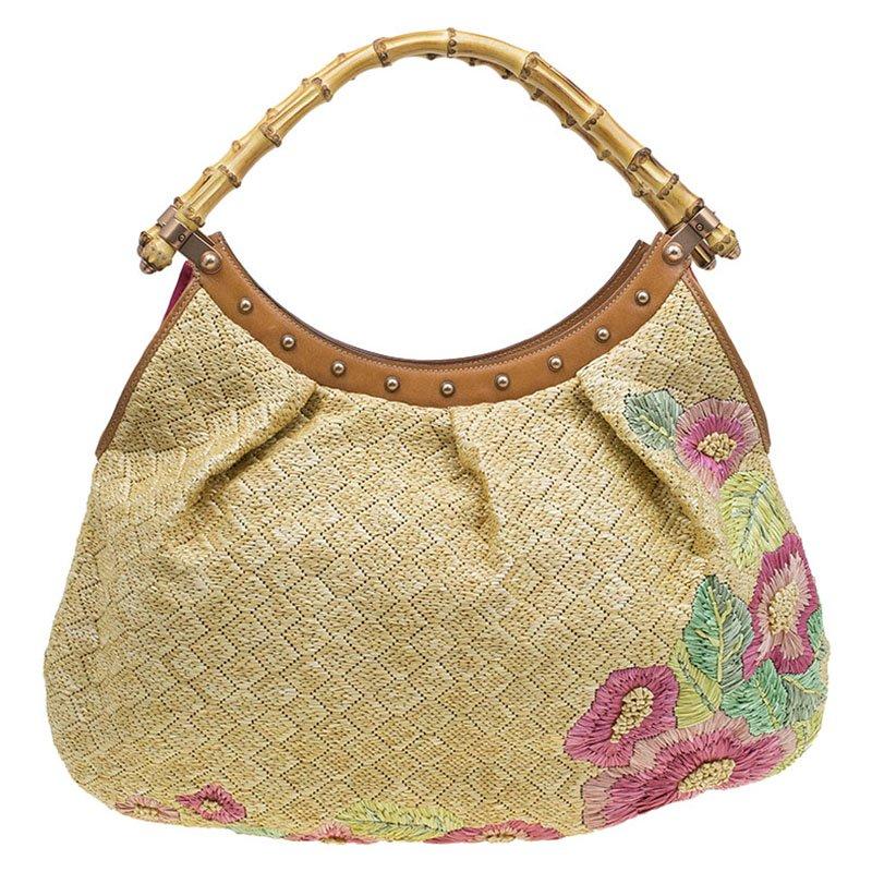 Redefining luxury for the 21st century, Gucci is one of the most well-known luxury fashion brands. Smart and feminine, this hobo is crafted in beige raffia with floral print motifs on the exterior body. It is decorated with dual bamboo handles and