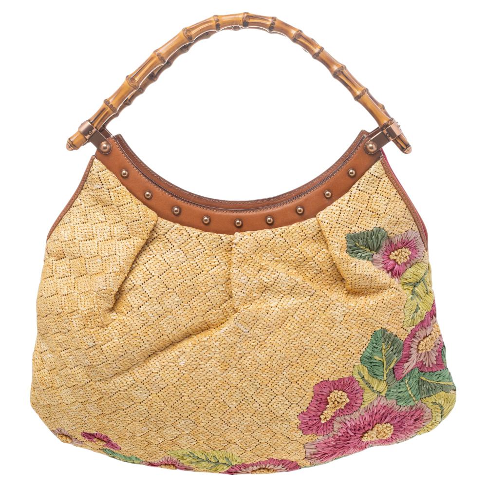 Als Neudefinition von Luxus für das 21. Jahrhundert ist Gucci eine der bekanntesten Luxusmodemarken. Diese elegante und feminine Hobo ist aus beigem Raffiabast gefertigt und mit floralen Prints auf dem Außenkörper versehen. Sie ist mit zwei
