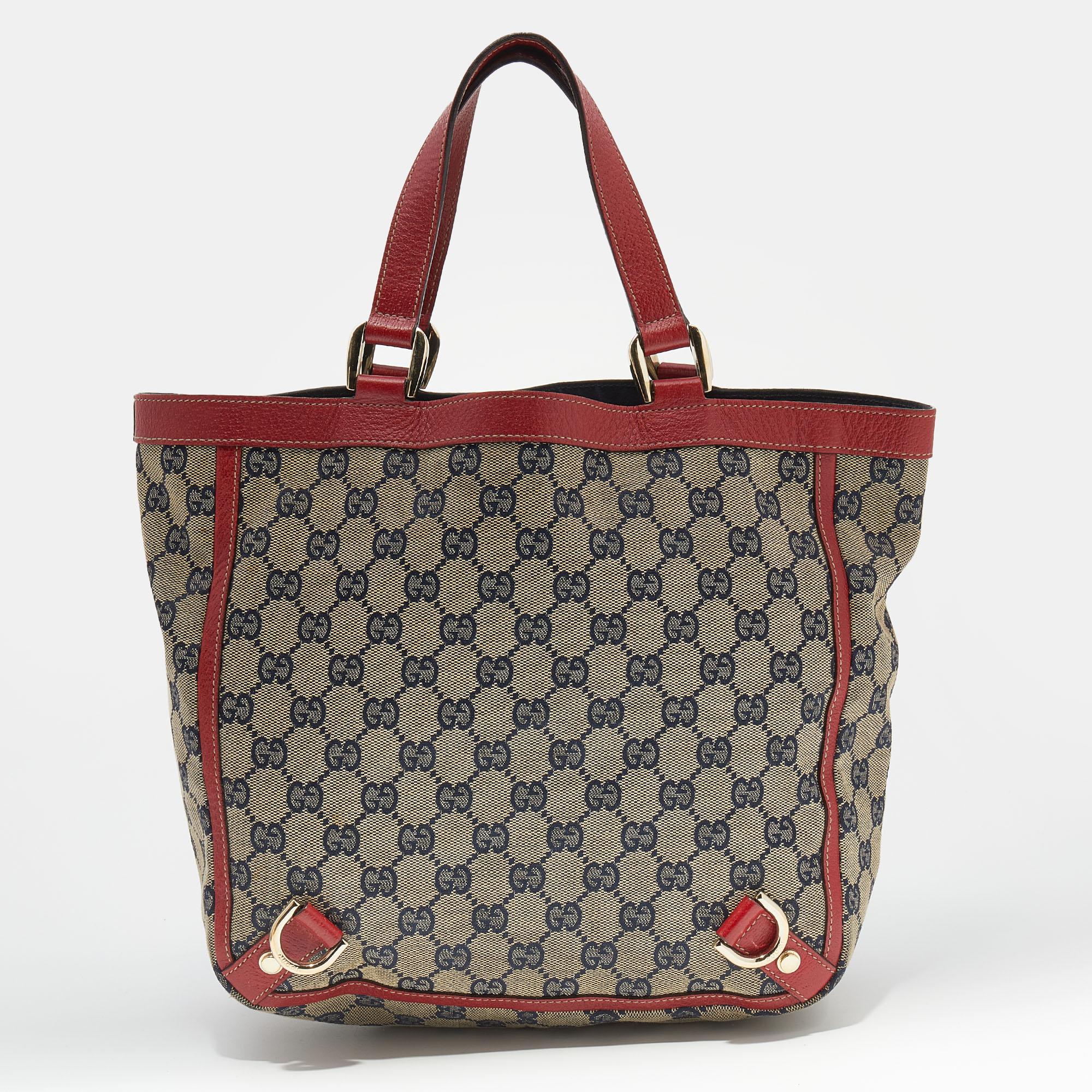 This Gucci hobo is all about balancing beauty with functionality. Created from the signature GG canvas, its exclusivity is enhanced with D-ring motifs, and it is held by dual handles at the top. The fabric-lined interior of the bag will keep your