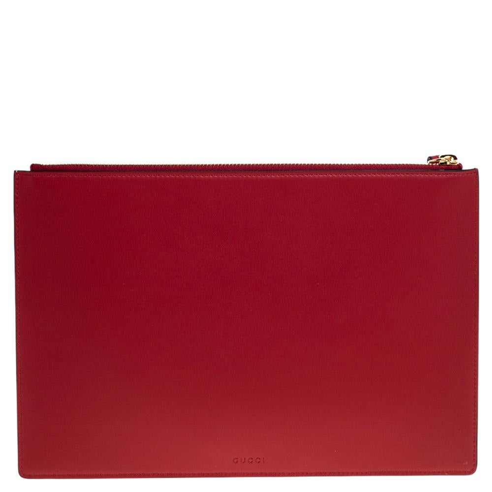 Add some magic to your everyday attire with this super stylish pouch. The bag by Gucci is made from GG coated canvas and red leather. The pouch is equipped with a spacious interior and is finished with a fun Bosco, the cat patch on the