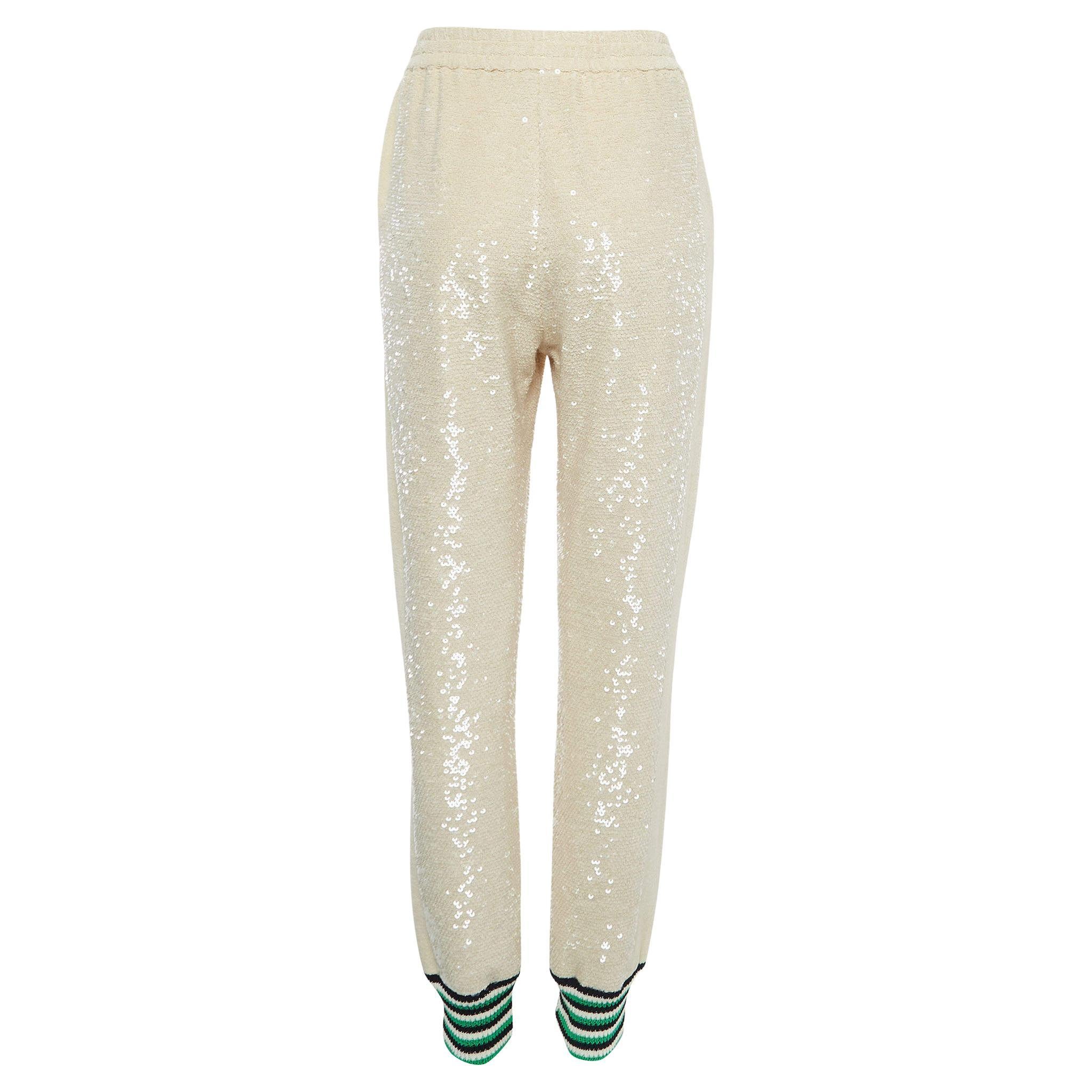 Die Gucci Jogginghose bietet eine luxuriöse Mischung aus Komfort und Stil. Die aus hochwertiger Baumwolle gefertigte Jogginghose ist in einem beigen Farbton gehalten und mit Pailletten verziert, die für einen glamourösen und mühelos schicken Look