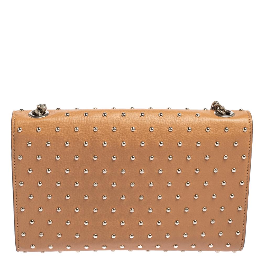 This Gucci Miss Bamboo bag is effortlessly classy and is perfect to carry throughout the day. It has a leather exterior enhanced with silver-tone metal studs. It features a front flap with a bamboo twist-lock closure and a leather-lined interior. A