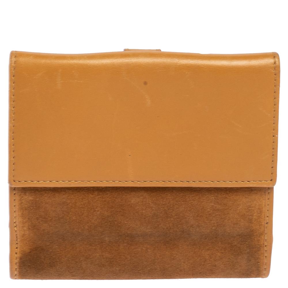 Geldbörsen wie diese von Gucci sind ein Muss, denn sie sind nicht nur funktional, sondern auch elegant. Dieses kompakte Portemonnaie aus Wildleder und Leder ist mit einem charakteristischen Schloss verziert und hat zwei Öffnungen. Während die