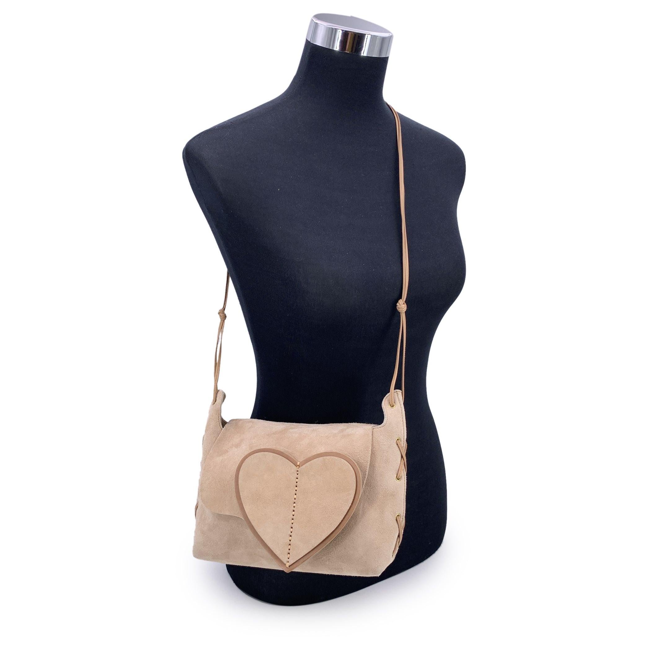 Charmant et plein de caractère, cet authentique sac à bandoulière Gucci Heart Flap en daim beige doux est un doux clin d'œil à la fantaisie et à l'élégance du début des années 2000. Avec son rabat en forme de cœur et sa fine bandoulière polyvalente,