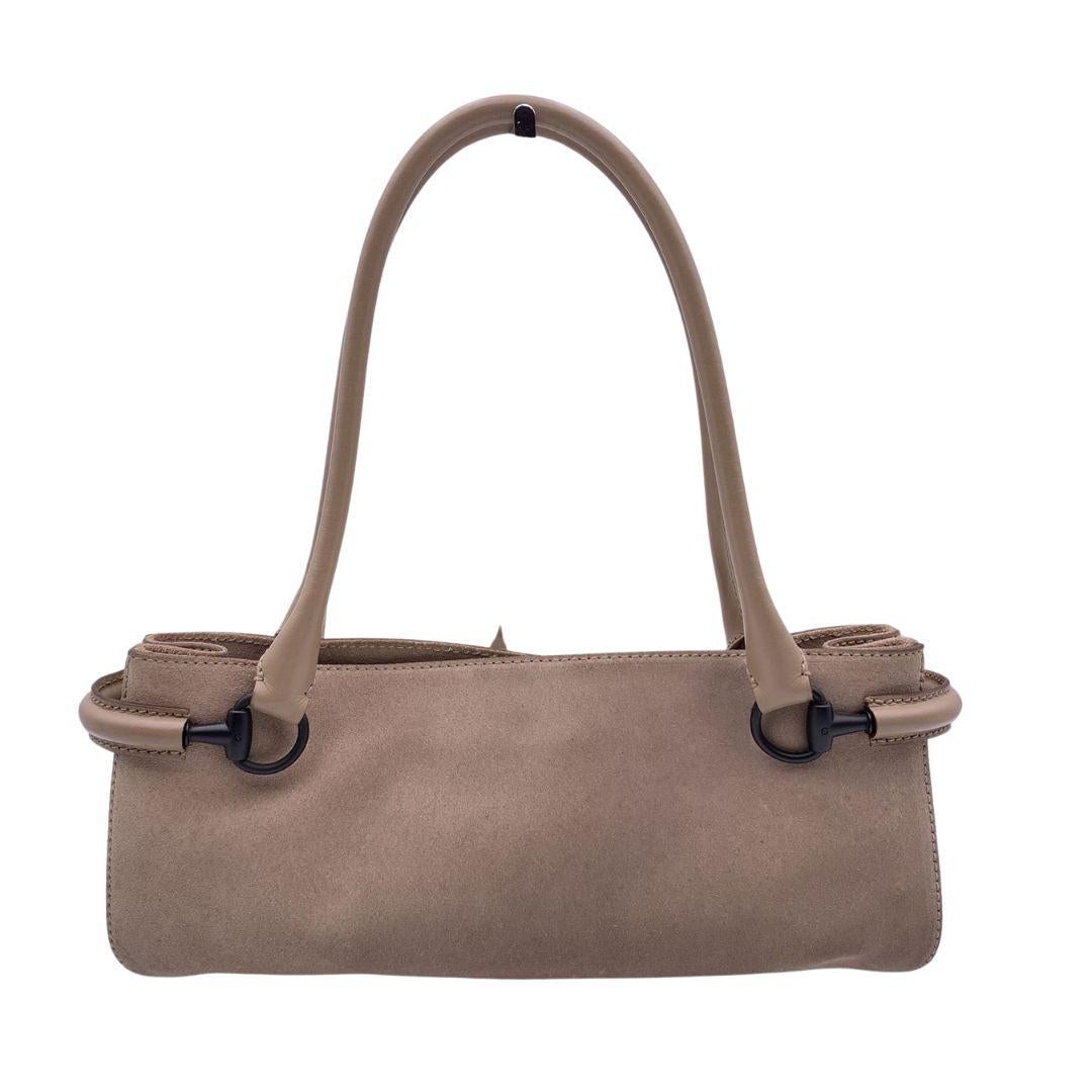 Beautiful Gucci east west tote bag in beige suede and leather. Double rolled shoulder straps. Horsebit detailing on the sides. Magnetic button closure on top. Brown canvas lining. 1 side zip pocket inside. 'Gucci - Made in Italy' tag inside (serial