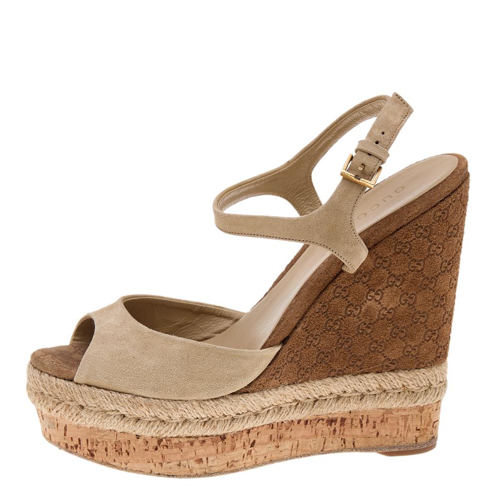 Treat your feet to these sandals from Gucci. They are made from beige suede and come with wedge espadrilles, peep-toes, and an ankle strap. These sandals are fitted with gold-toned hardware. Wear them with your casual attire and look gorgeous!