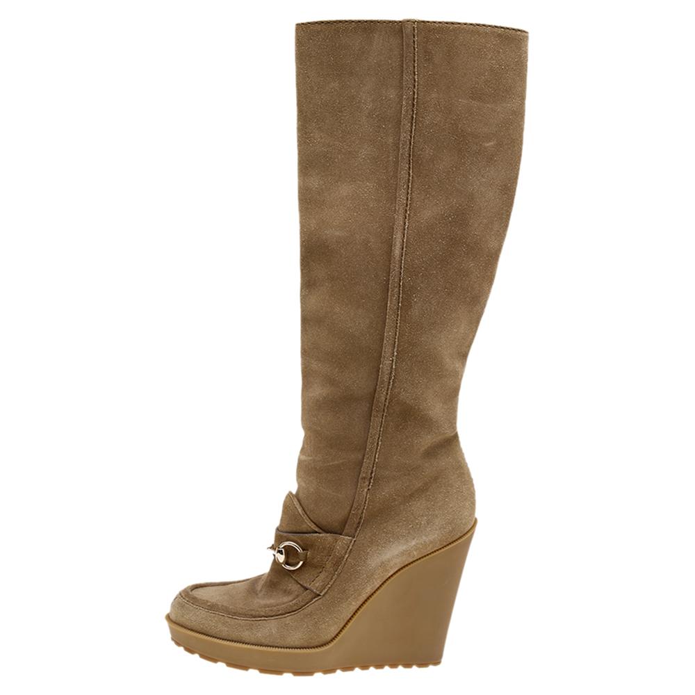 Creations as fashionable as this pair of knee-length boots from Gucci deserve to be in every woman's closet. These designer boots have been created using beige suede and added with round toes, signature motif, side zip closure, and wedge heels.