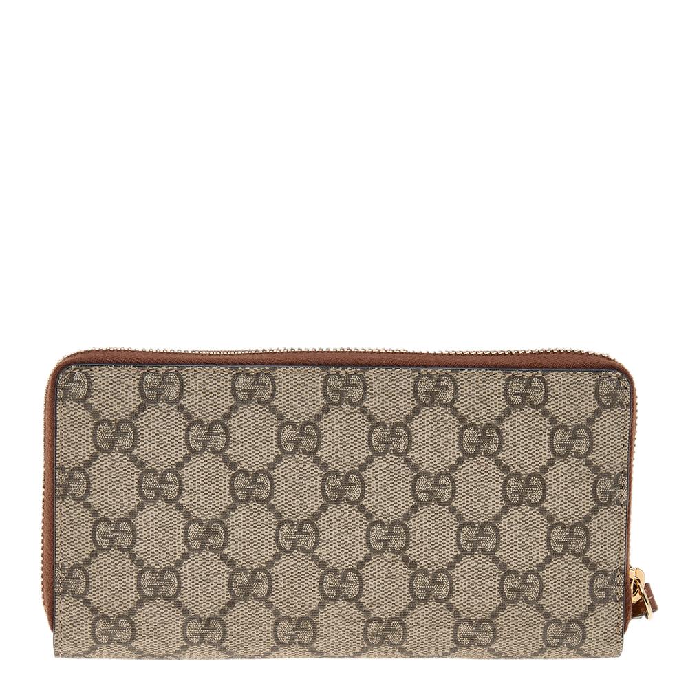 Coming from the house of Gucci, this wallet is a beauty to own. It features a tan and beige 'GG' Supreme coated canvas body and is secured with zip closure. It features a leather and fabric interior with zip pocket, open space, side slots and card