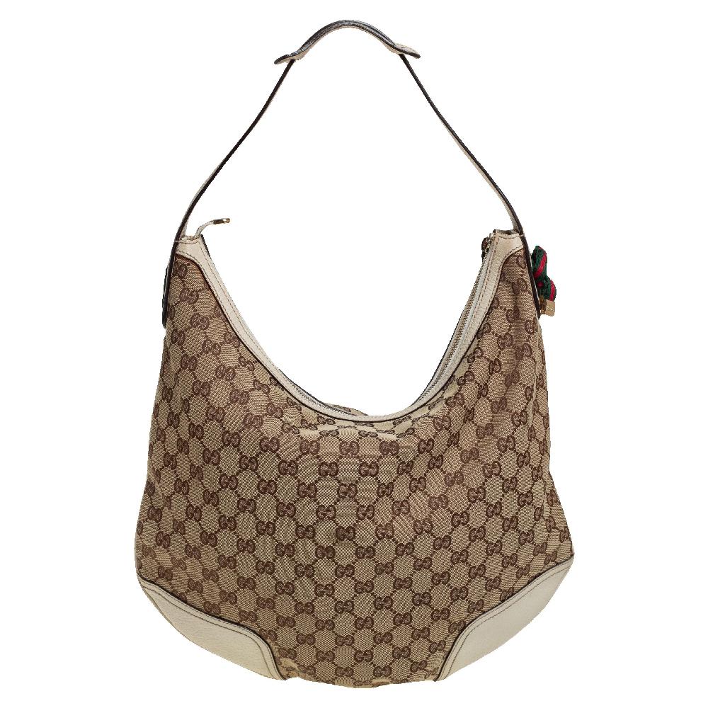 Crafted from GG canvas and leather, this hobo from Gucci is designed with minimal style details but with high attention to craftsmanship so that it may assist you with durability. The spacious interior of the bag is lined with fabric and secured by