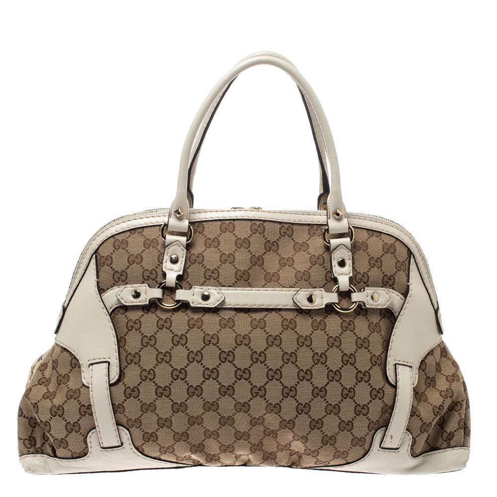 This Gucci Horsebit Nail Dome satchel is simply breathtaking. Meticulously crafted from beige GG canvas and white leather, the bag delights not only with its appeal but structure as well. It features the signature horsebit detail in gold-tone to the