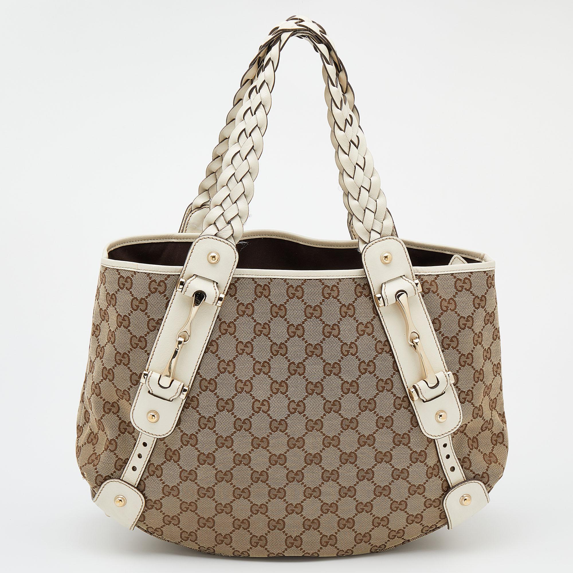 Make a striking appearance with this Pelham shoulder bag by Gucci. This elegant creation is at once a fashion statement as well as a rational necessity. It is crafted from beige-white GG canvas and leather. This bag is completed with gold-tone