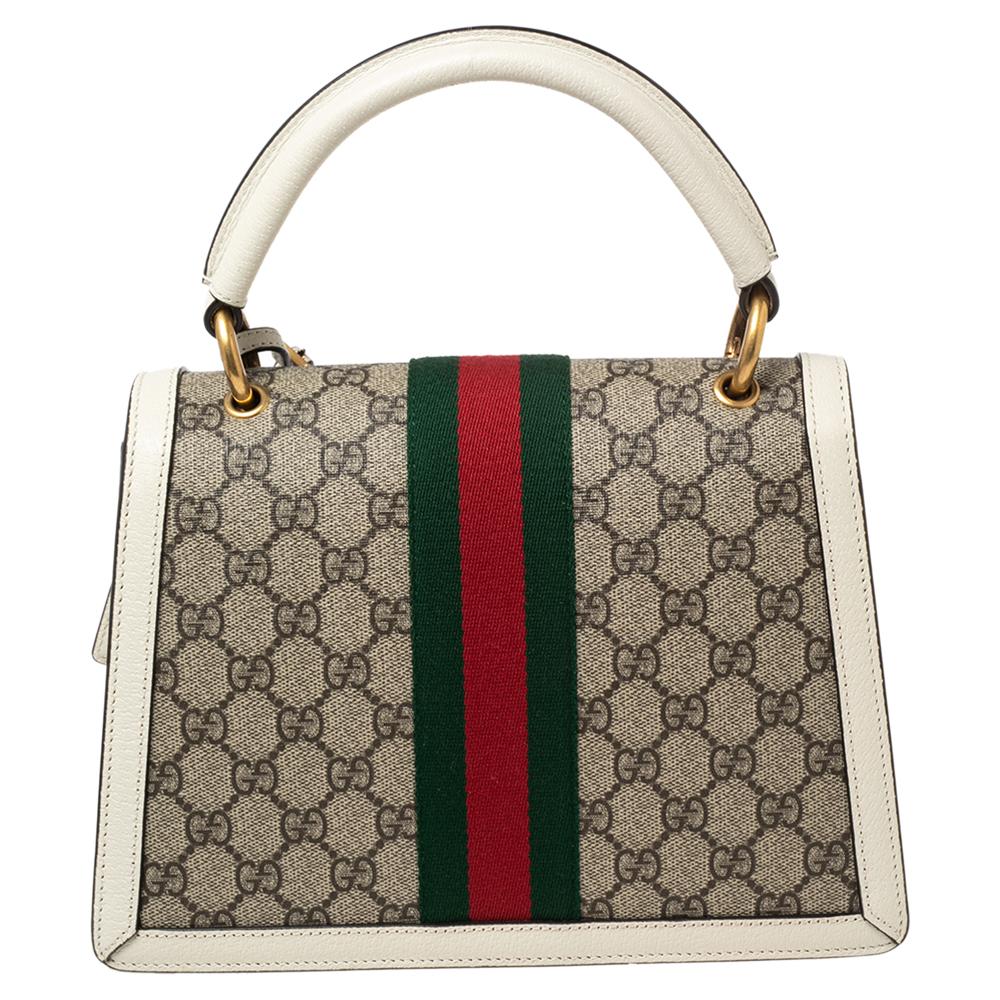 From the house of Gucci, this Queen Margaret bag is a grand fusion of brilliance and timeless style. Exhibiting signature elements in full light, the top handle leather bag has an embellished flap, a top handle, a shoulder strap, and an Alcantara