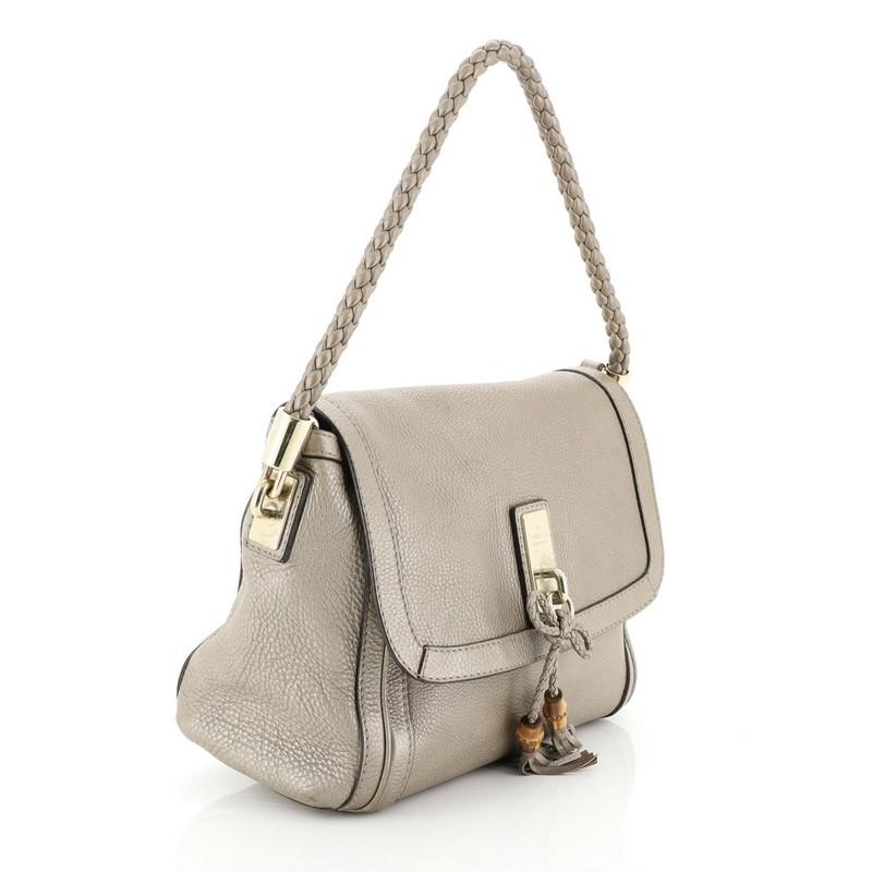 This Gucci Bella Flap Shoulder Bag Leather Medium, crafted from neutral leather, features a braided top handle, leather tassels, and gold-tone hardware. Its flap opens to a neutral fabric interior with zip and slip pockets. 

Estimated Retail Price: