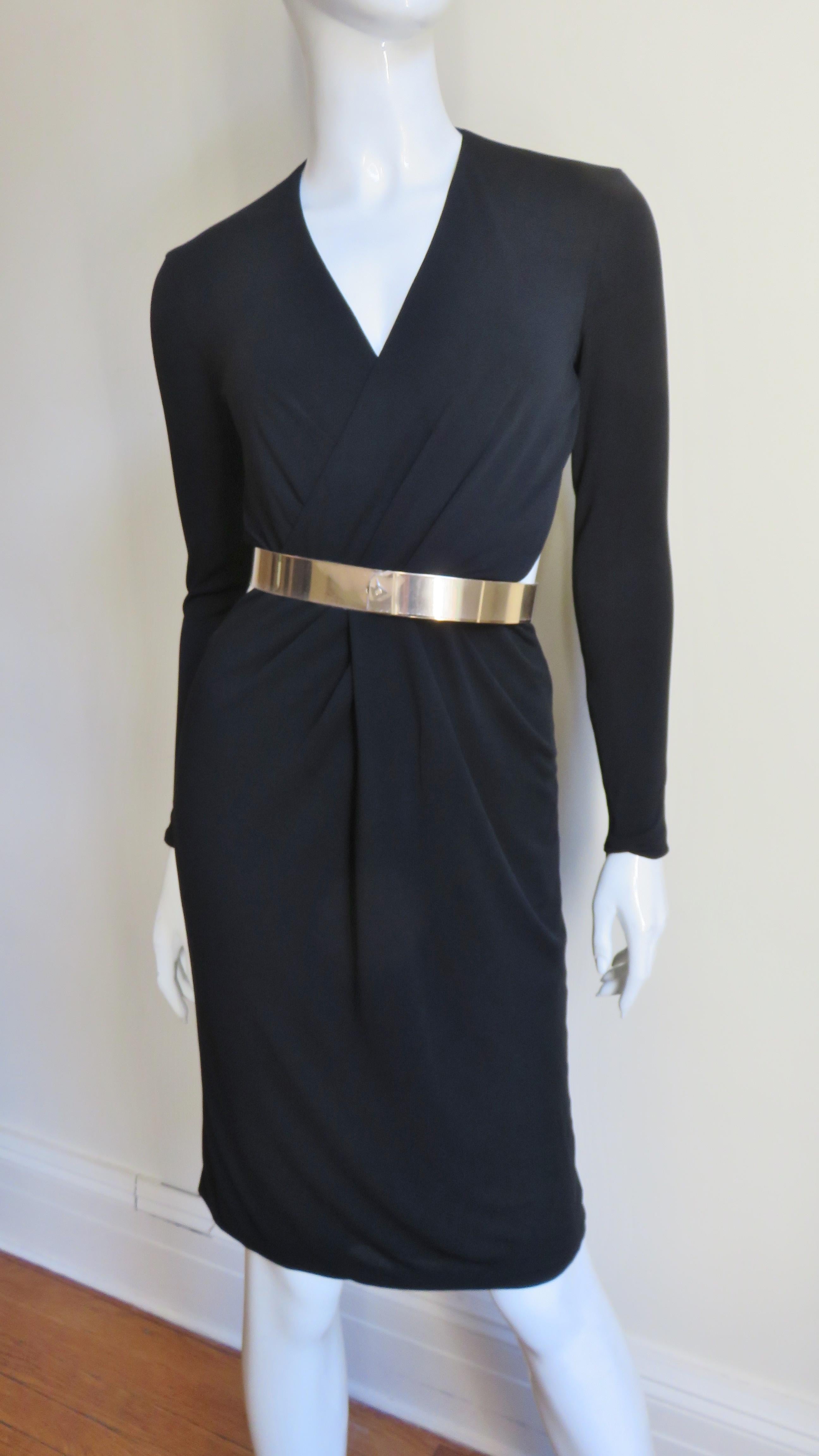 A gorgeous black silk jersey dress from Gucci.  It has a front crossing V neck, long sleeves with zippers and cut outs at the side waist.  The skirt is straight and the back is dramatically cut out from the neck to just below the waist.  It is lined