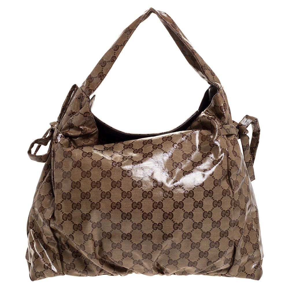 This Gucci hobo is built for everyday use. Crafted from GG crystal coated canvas, it has a glossy exterior and a single handle for you to easily parade it. The nylon insides are sized well and the hobo is complete with the signature