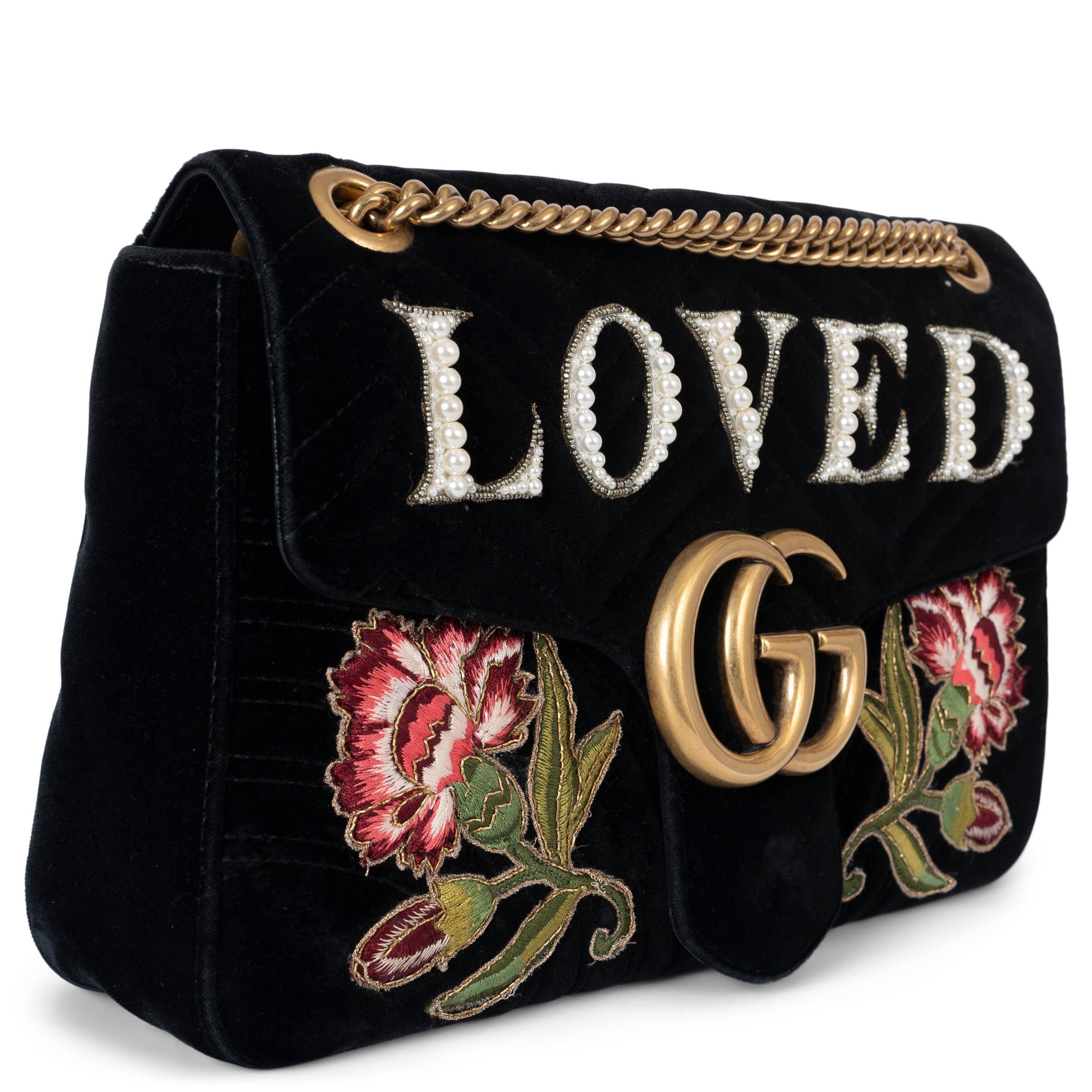 This 100% authentic Gucci GG Marmont Medium Matelassé flap shoulder bag in black quilted velvet is adorned with “Loved” writing in faux pearls and floral embroidery on the front, adding a romantic touch to the iconic design. Featuring the classic GG