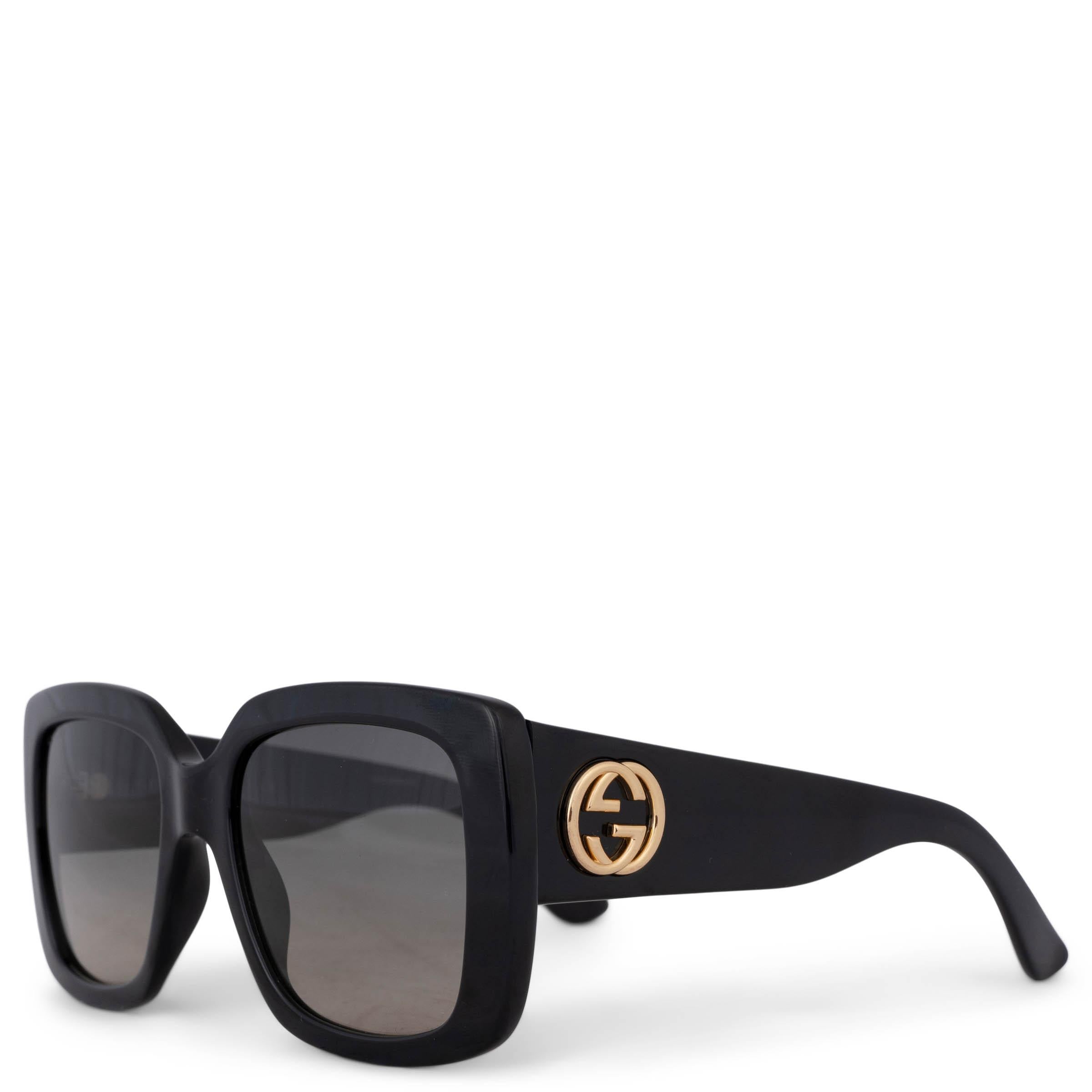 These 100% authentic Gucci square sunglasses are crafted from black acetate and feature gradient grey lenses. The design includes a full rim frame with wide arms, adorned with gold-tone interlocking GG logos, adding a touch of luxury to this bold,