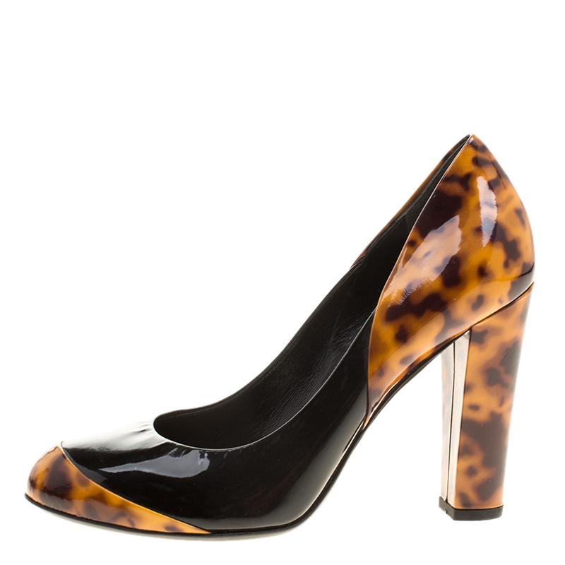 Super-comfortable and loaded with style, this pair of Gucci pumps will make your feet stand out. They've been crafted from patent leather, designed with tortoise accents, round toes and block heels. The pair is sure to delight your dresses and