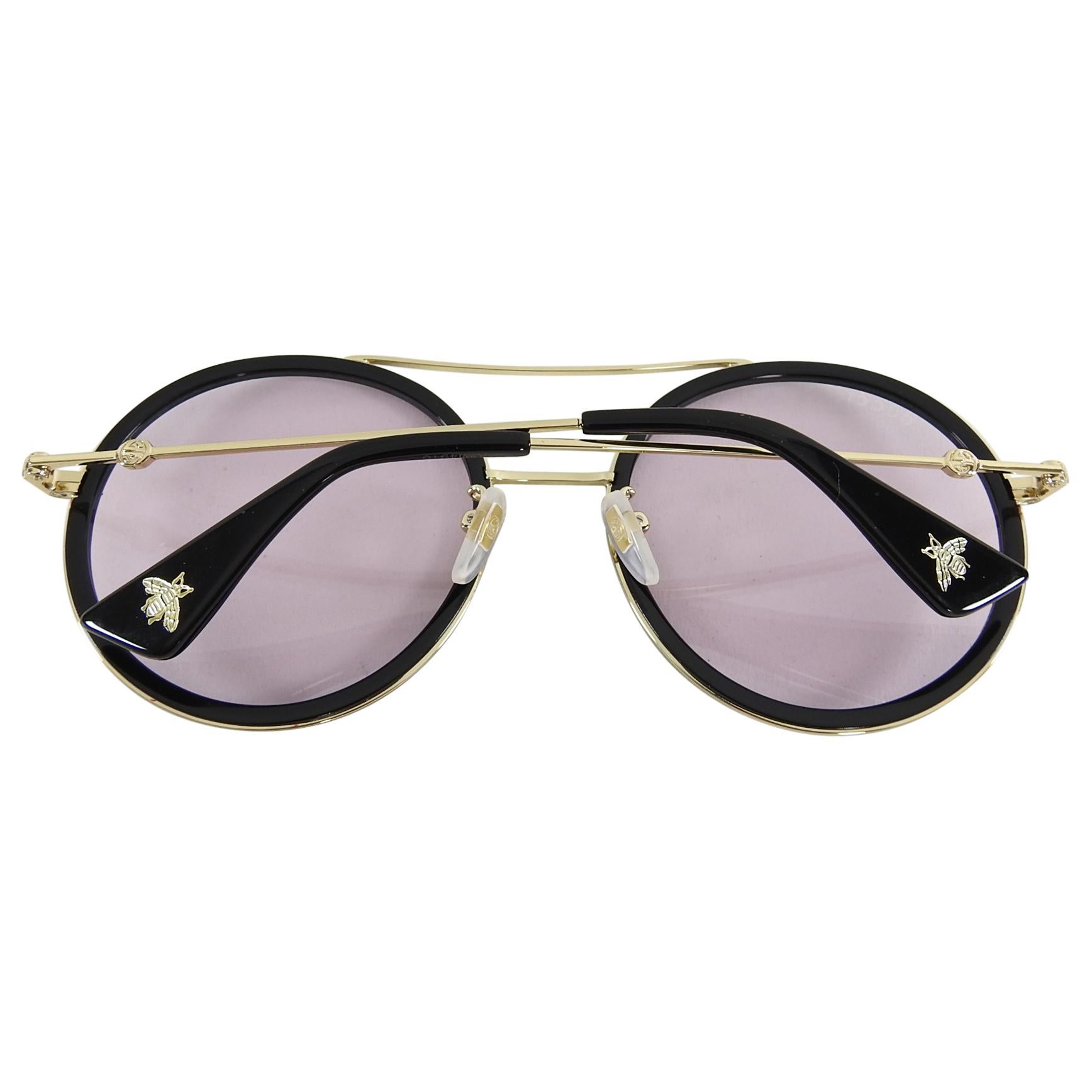 Gucci Black and White Round Light Tint Sunglasses GG0061S.  Black and white enamel round sunglasses with gold metal frame.  Light lavender tint lens. Excellent pre-owned condition with case and care papers.