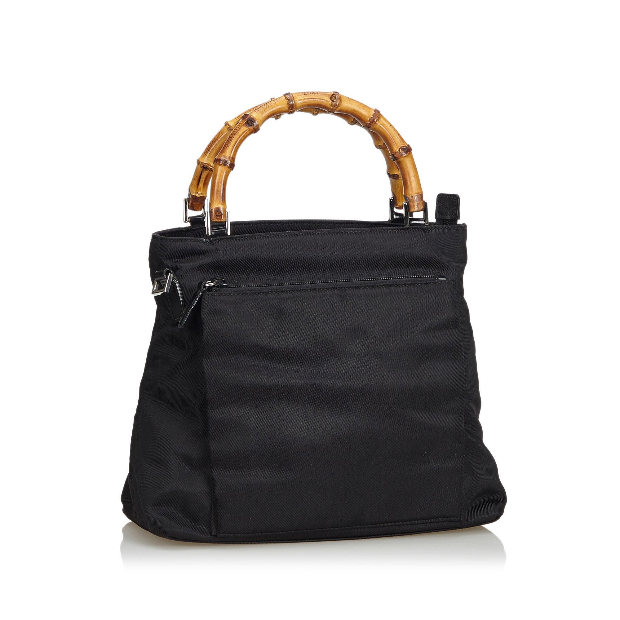 This satchel features a nylon body, an exterior zip pocket, a bamboo top handle, a flat leather strap, a top zip closure, and interior zip pocket. It carries as AB condition rating.

Inclusions: 
This item does not come with