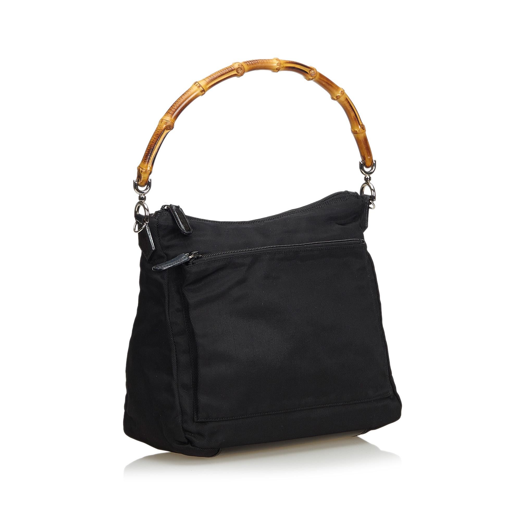 This satchel features a nylon body, an exterior zip pocket, a bamboo top handle, a flat leather strap, a top zip closure, and interior zip pocket. It carries as B+ condition rating.

Inclusions: 
This item does not come with