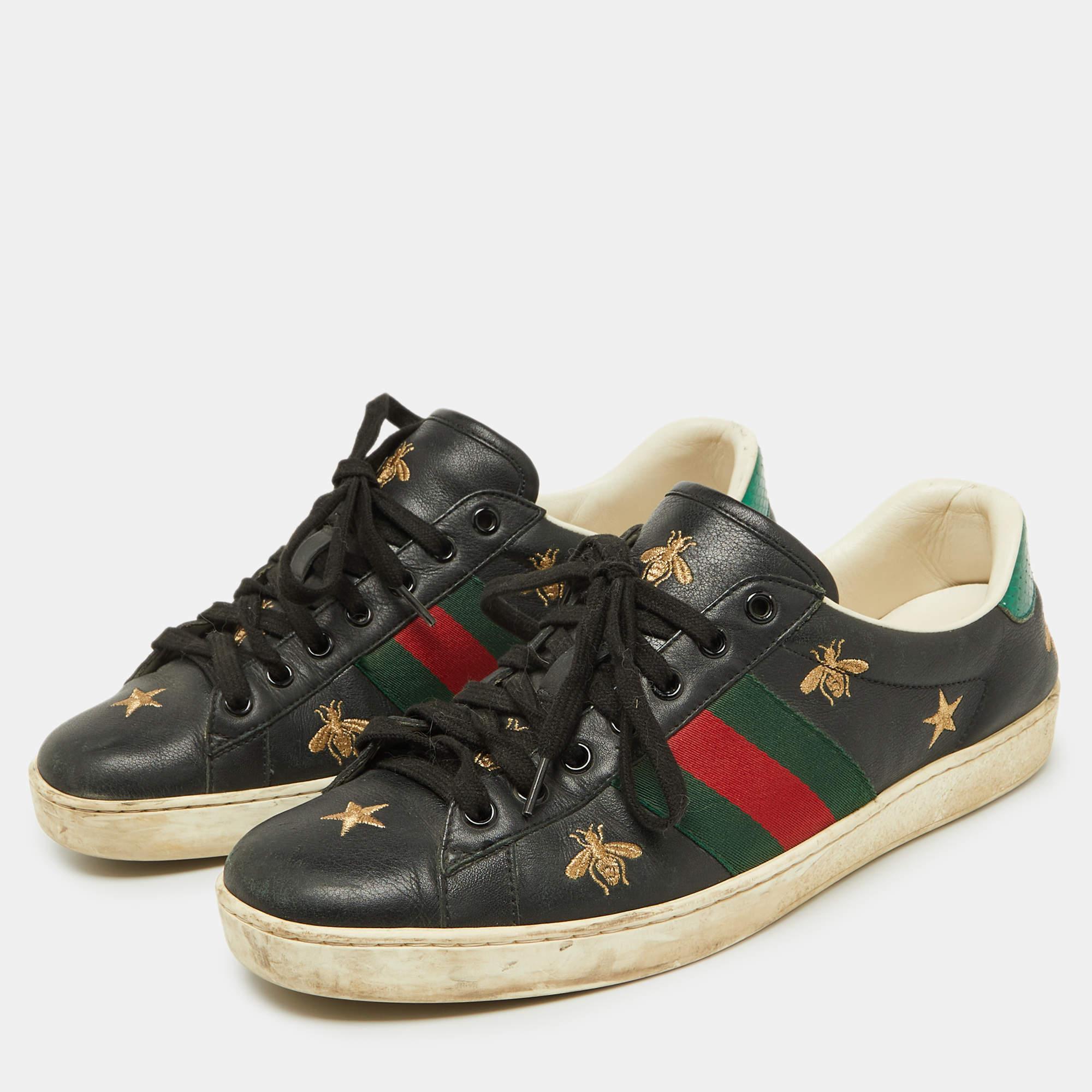 Con detalles de la firma, este par de Gucci está confeccionado en piel y tiene un diseño de corte bajo con cordones en la parte superior. Se han confeccionado con las icónicas rayas de tela de araña y bordados de abejas y estrellas. Completados con