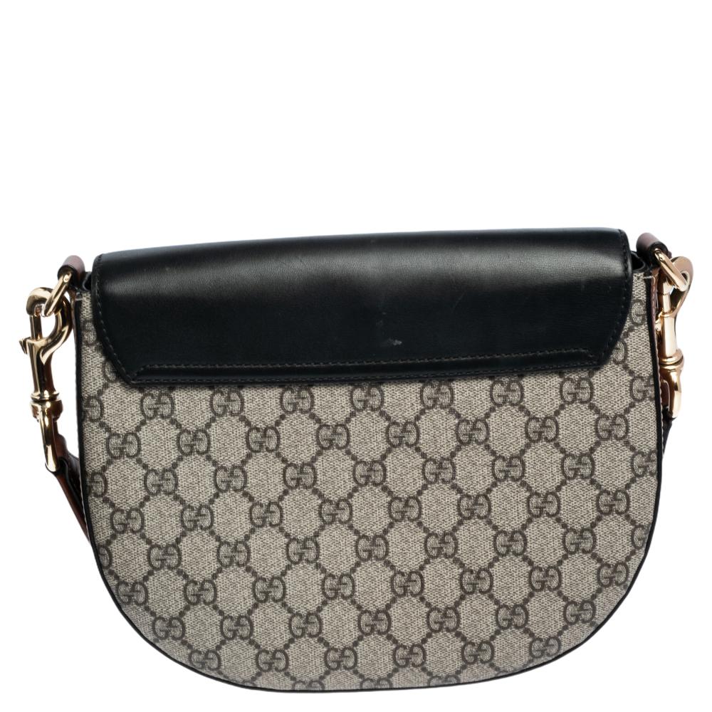This chic and contemporary Gucci bag will help you outline a stylish look and outshine everyone else! Crafted from GG Supreme canvas and leather, it has black & beige hues. The structured silhouette is secured with a lock-accented front flap and