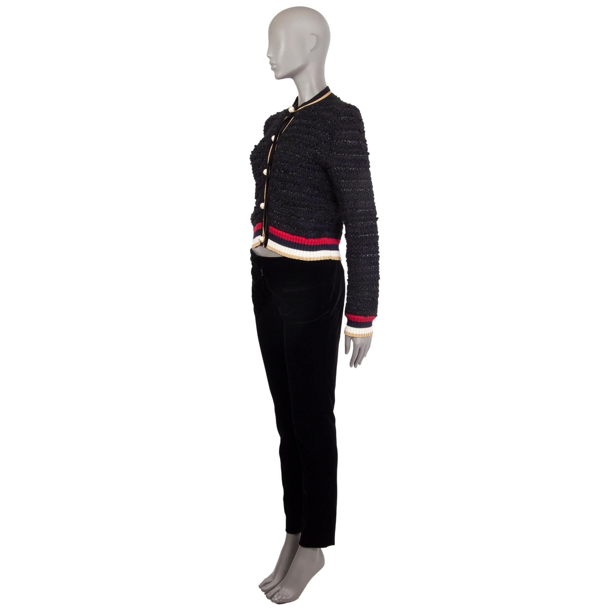 Gucci boucle-knit cardigan in black, gold, red, navy, and off-white nylon (85%) and mohair (15%); nylon (40%), viscose (38%), and paper (22%); and wool (73%) and nylon (27%). With crew neck, and ribbed details. Closes with GG pearl buttons on the