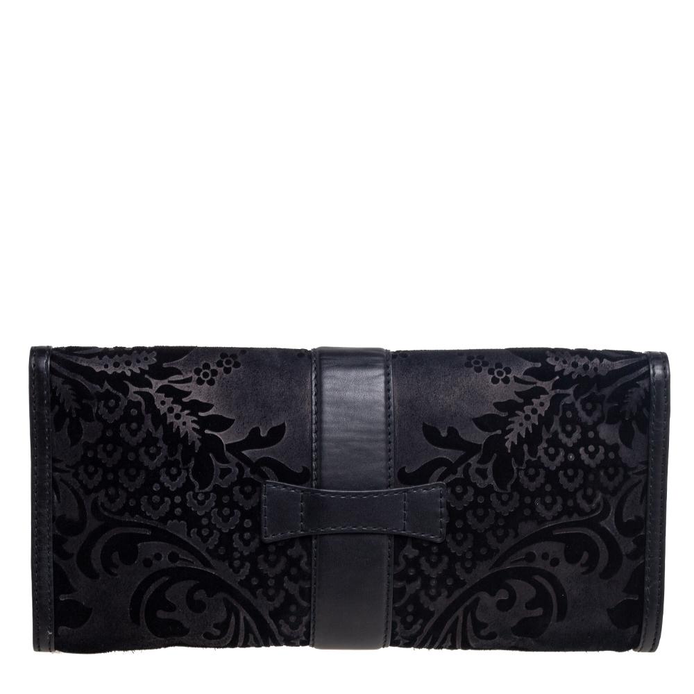 This clutch by Gucci is a creation that is not only stylish but also exceptionally well-made. Meticulously crafted from brocade suede and leather, it is highlighted by a gold-tone motif on the front. The flap leads to a well-sized interior for your