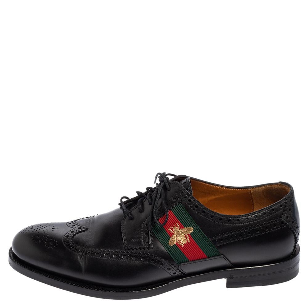 Smart and very suave, these derby shoes from Gucci are made for fashionable men like you! They are crafted using black brogue leather on the exterior and flaunt lace-up details, the signature Web strap detailing, and a gold-toned embroidered Bee