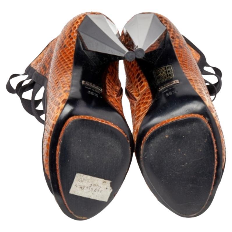 Aiguës et chics, ces bottes de Gucci dessinent une silhouette séduisante de jour comme de nuit. Confectionnées en daim noir et en cuir de python marron et dotées d'une bande élastique sur l'empeigne, elles sont montées sur des talons ultra-modernes