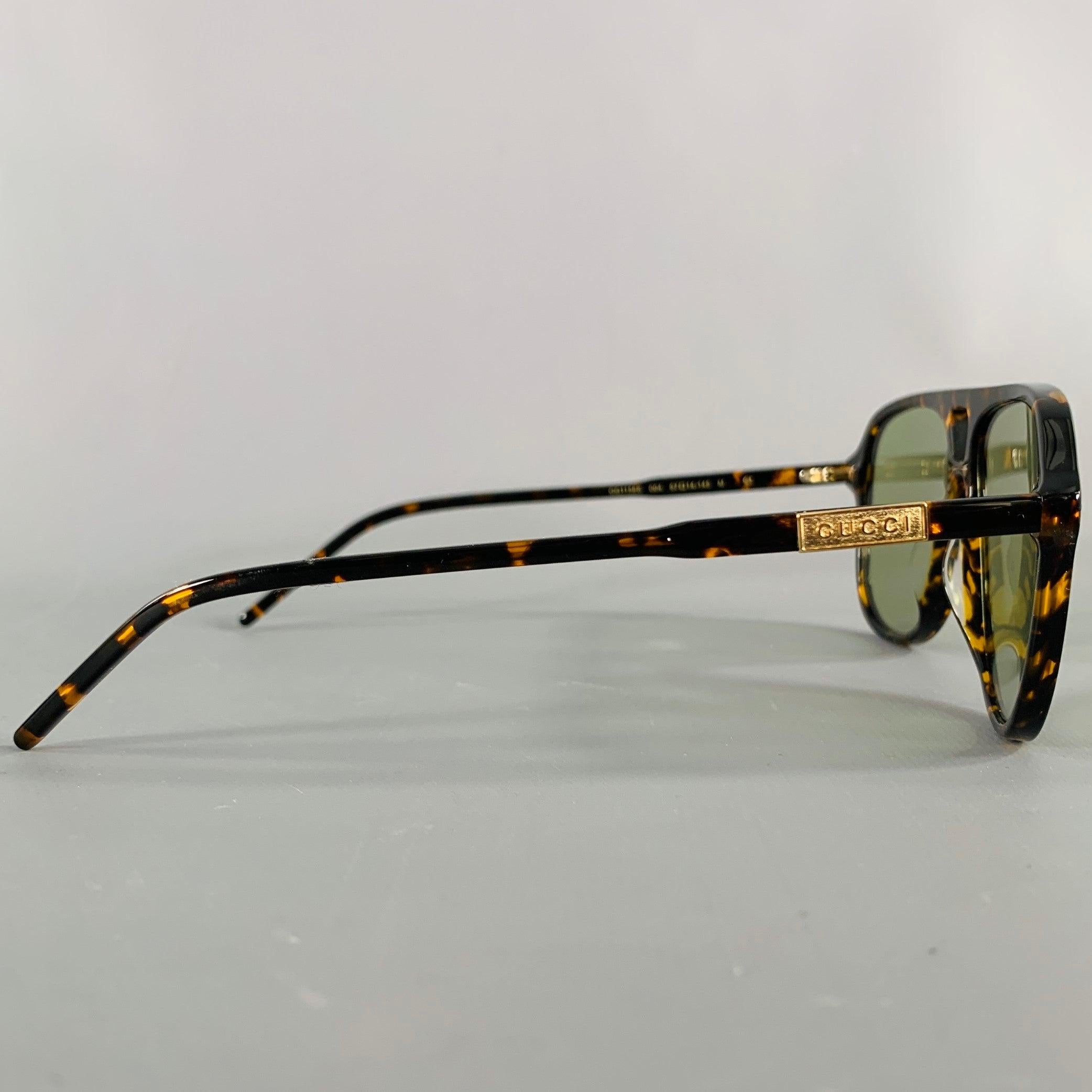 GUCCI sunglasses
in a black and brown acetate featuring a tortoiseshell pattern, teardrop aviator style, and tinted lenses. Comes with case. Made in Italy.Very Good Pre-Owned Condition. 

Marked:   GG1156S 004 57 14 145 M 

Measurements: 
  Frame