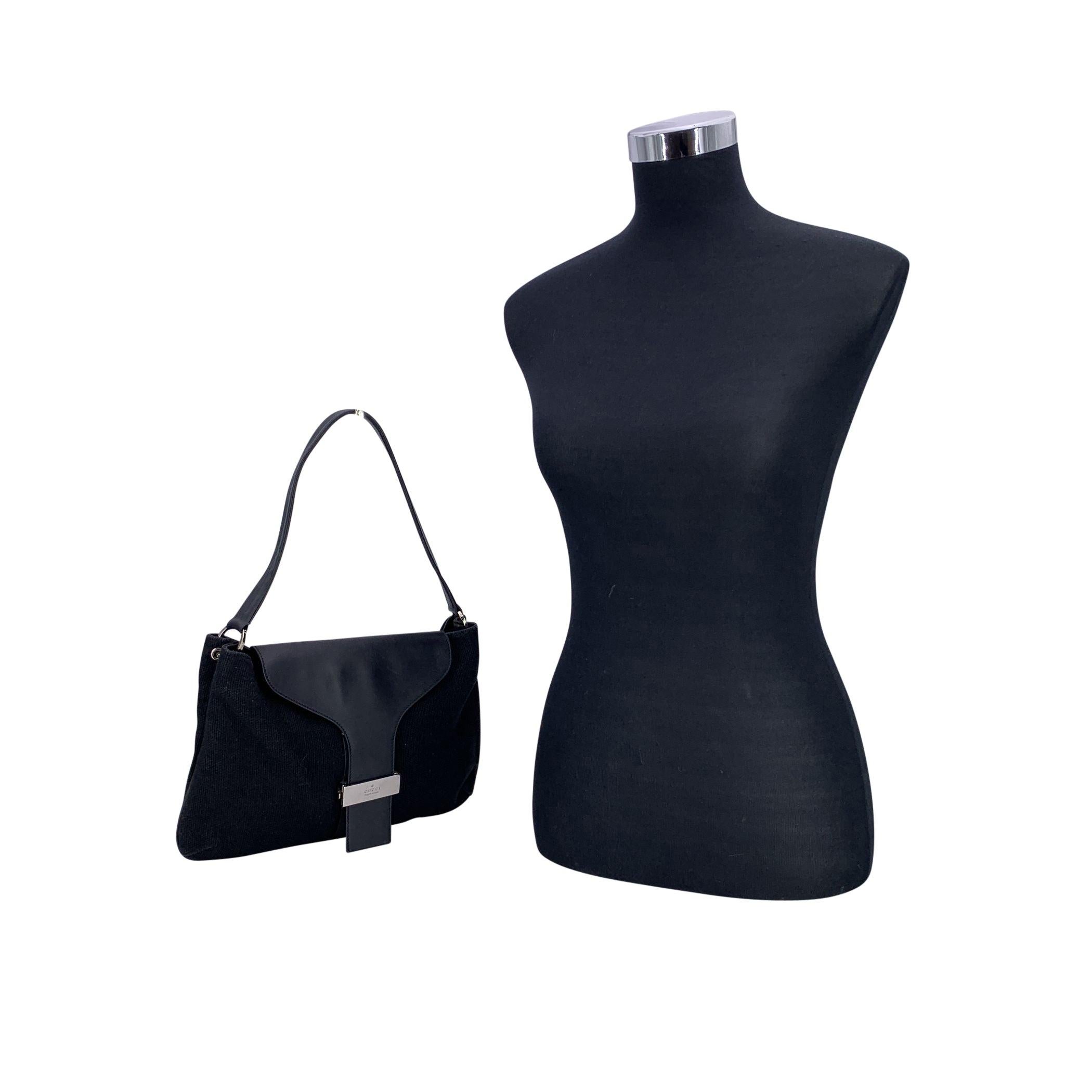 Elegne et minimaliste, ce sac à bandoulière vintage Gucci est fabriqué en toile noire et doté d'un rabat et d'une bandoulière en cuir noir - un mélange intemporel d'élégance décontractée et de design italien emblématique. La fermeture à rabat révèle