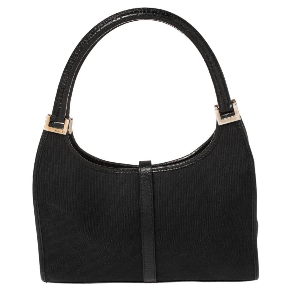 A handbag should not only be good looking but also durable, just like this pretty black Jackie O shoulder bag from Gucci. Crafted from black classic GG canvas in Italy, this gorgeous number has a signature closure that opens up to a spacious