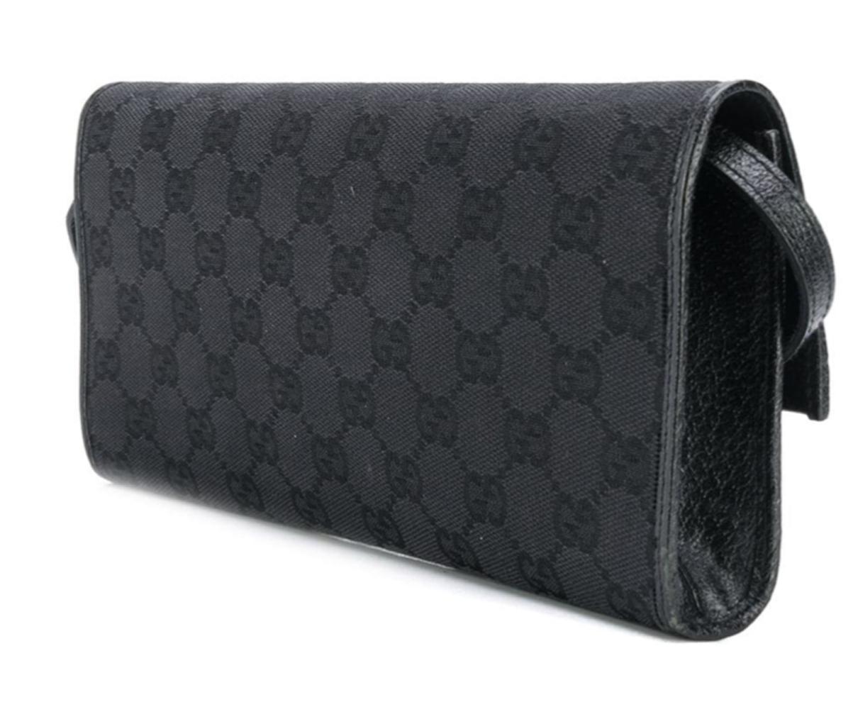Gucci black canvas & leather clutch bag featuring a monogram pattern, a leather detachable shoulder strap, black bamboo detail, a foldover top with magnetic closure, a main internal compartment, a full lining, an internal slip pocket