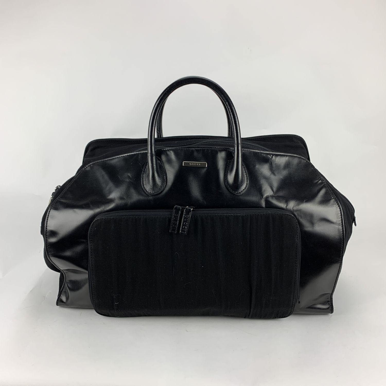 Gucci Black Canvas Travel Bag weekender bag. Black canvas and genuine leather. Top carry handles. Upper zipper closure. Silver metal hardware. Front zip pocket. 5 bottom feet. Black fabric lining . 1 side zip pocket inside. 'GUCCI - made in Italy'