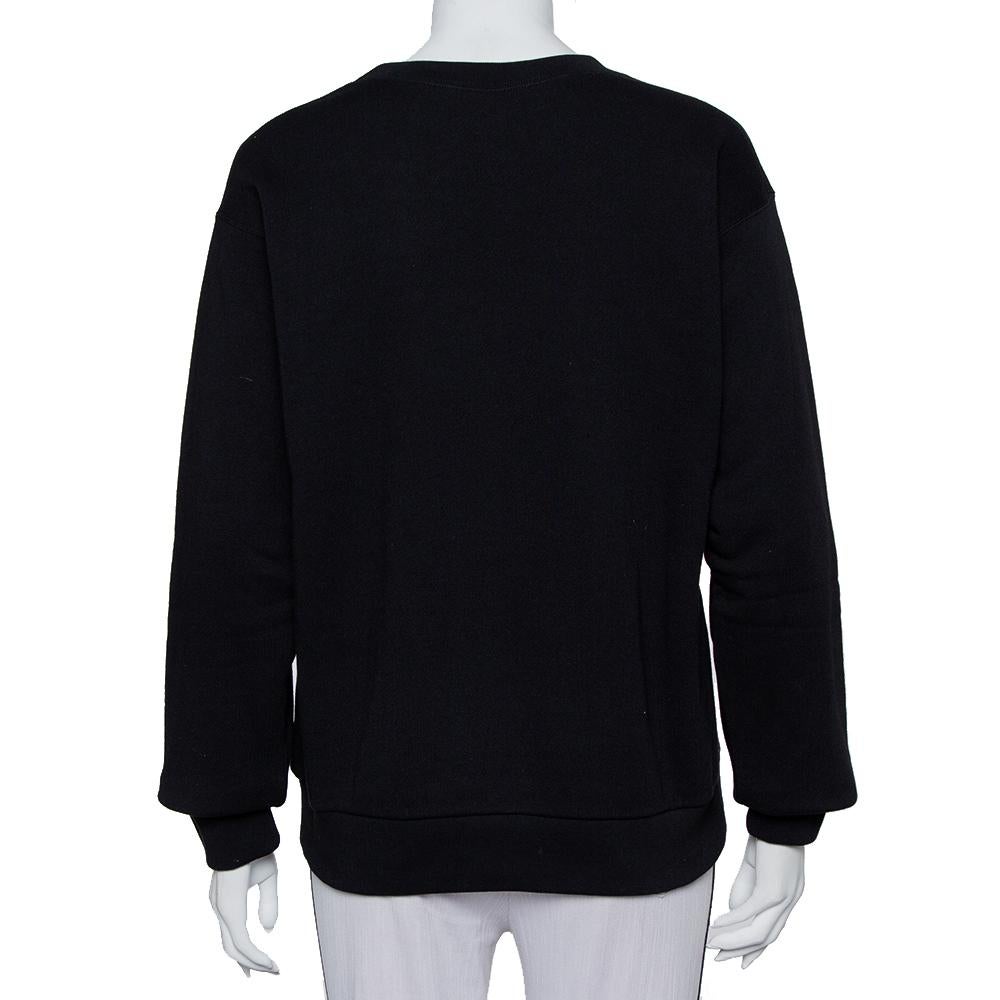 A black crewneck sweatshirt by Gucci featuring embellished logo heart detail on the front. Made from cotton, it features long sleeves and a comfortable fit.

Includes: Brand tag
