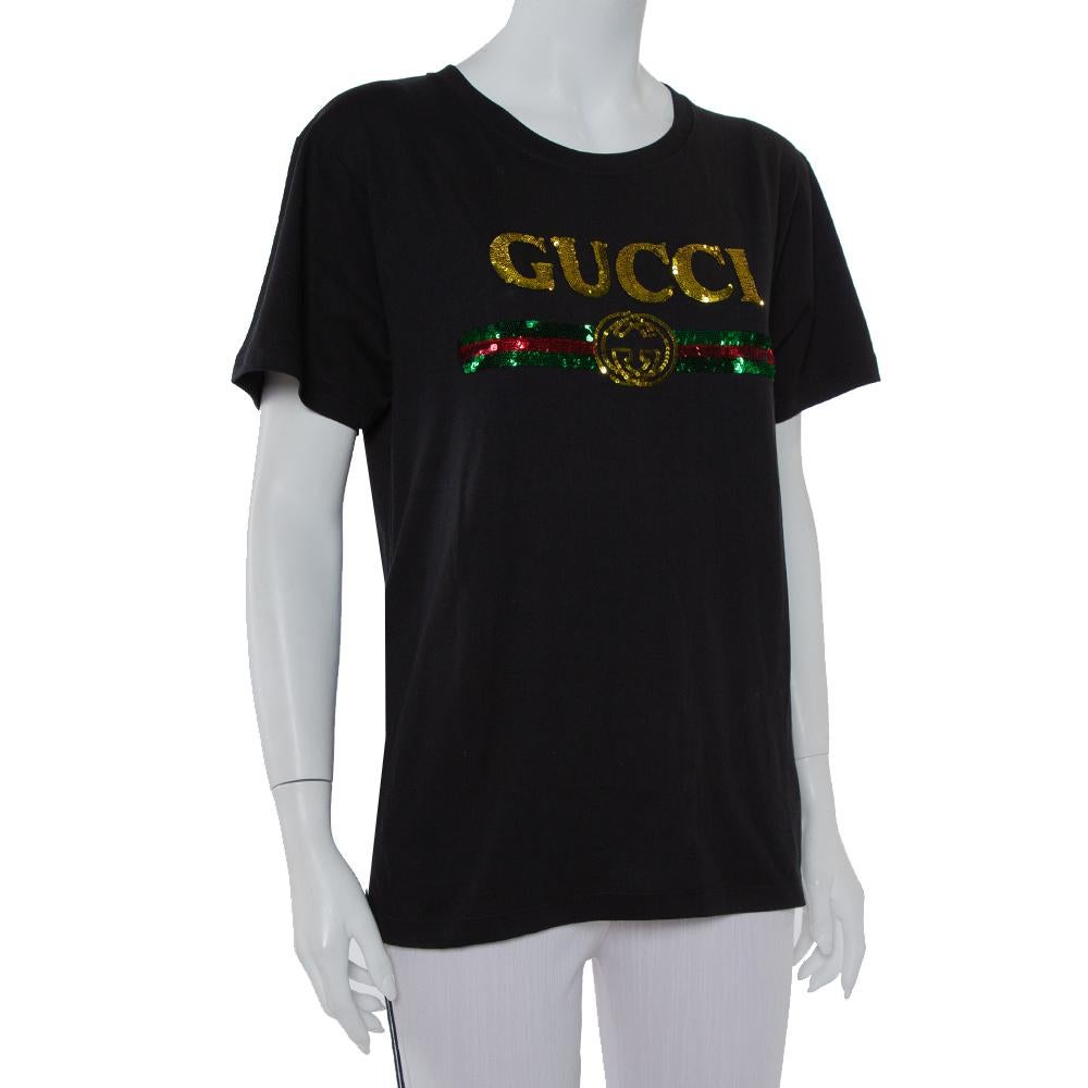 A simple silhouette gets a dazzling update in this Gucci t-shirt! Made from 100% cotton in a black shade, it flaunts the Gucci logo on the front and a Tiger motif at the back embellished with sequins, it also showcases the label's love for vintage