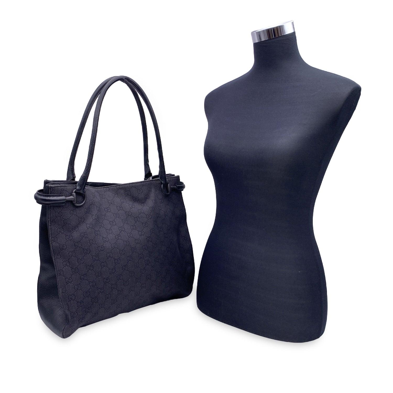 Magnifique sac shopping tote de Gucci en toile denim noire. Poignées et bordures en cuir noir. Etiquette 'Gucci - Made in Italy' sur le devant. Doublure en toile noire. 1 poche latérale zippée à l'intérieur. Etiquette 'Gucci - Made in Italy' à