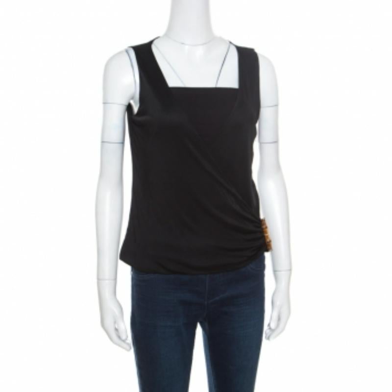 Este top sin mangas de Gucci es elegante y tiene clase. El top luce un tono negro y una parte delantera drapeada con un detalle de hebilla de bambú. Quedará genial con unos vaqueros pitillo o unos pantalones y unos zapatos de tacón.