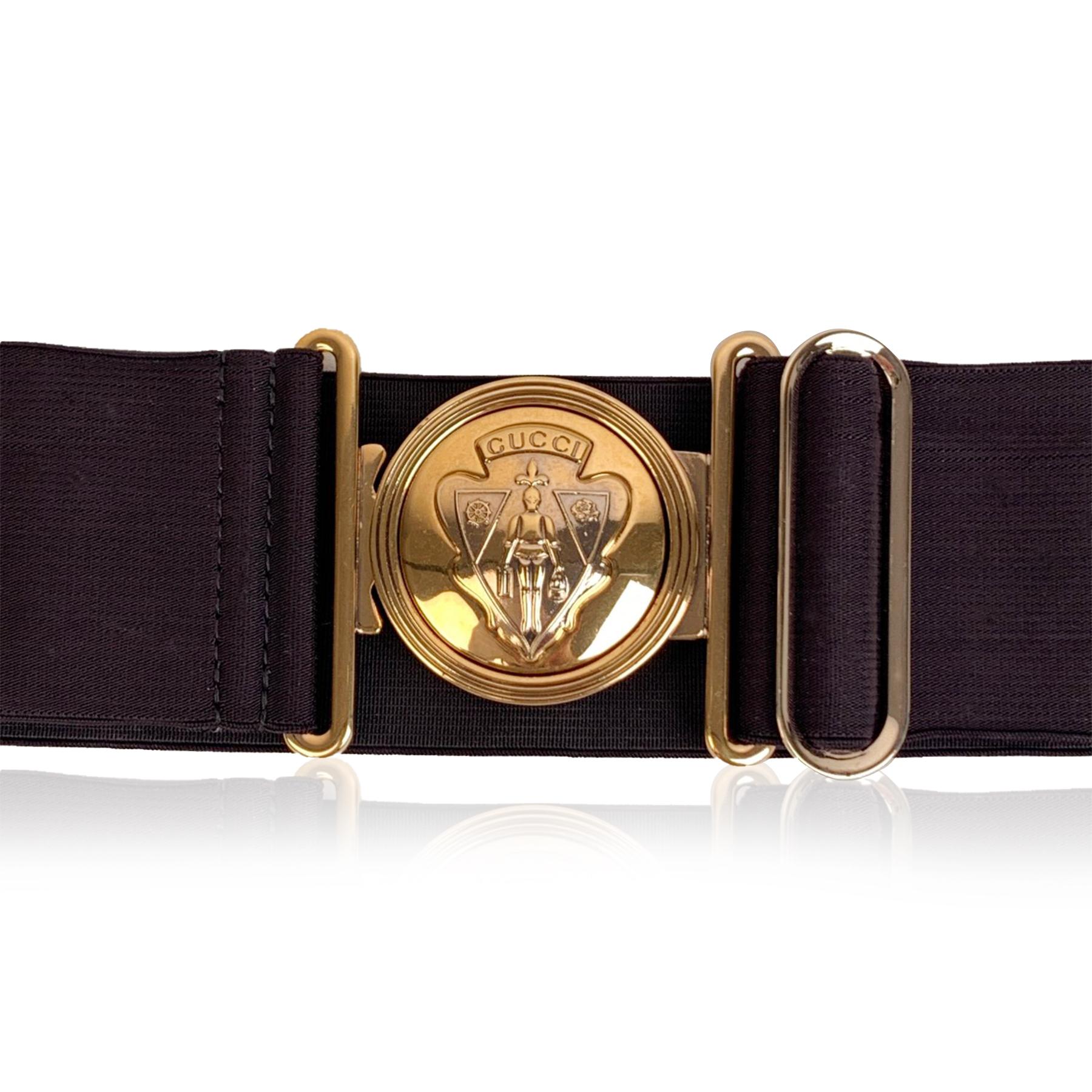 Gucci black 'Hysteria' elastic stretch belt, mod. 136124. It features gold metal round Gucci Crest buckle. Width: 2.25 inches - 5,7 cm. 'GUCCI - Made in Italy' tag on the reverse of the belt, serial number engraved on the reverse of the belt. Size: