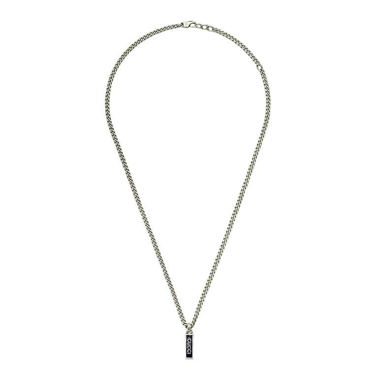 A contemporary Gucci necklace featuring a 'Gucci' engraved black enameled pendant. The sterling silver chain serves a timeless touch to accentuate any style. The clasp closure allows all day security for this shining chain.

- Model No.:
