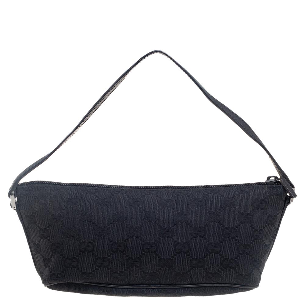This handy Pochette bag was skillfully created by the House of Gucci. It has been made using the black signature GG canvas and leather on the exterior with a gunmetal-toned logo plaque perched on the front. It is equipped with a nylon interior that