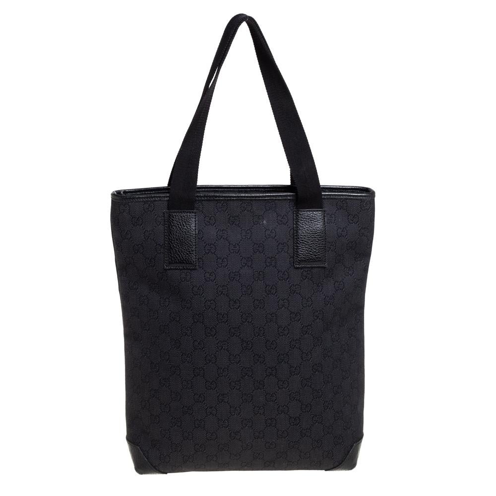This stylish Gucci GG canvas & leather vertical tote is a must have for your wardrobe. Crafted from black canvas, this tote is accented with black leather trims and features a front zip pocket. The top zipper opens to reveal a spacious interior