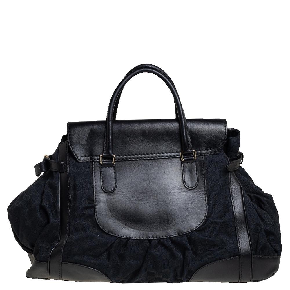 Go sophisticated with this black Queen tote by Gucci. Crafted from GG coated canvas & leather, it is detailed with distinctive stitching, a bow-shaped closure, and comfortable rolled leather handles. Its large interior is lined with nylon and has a