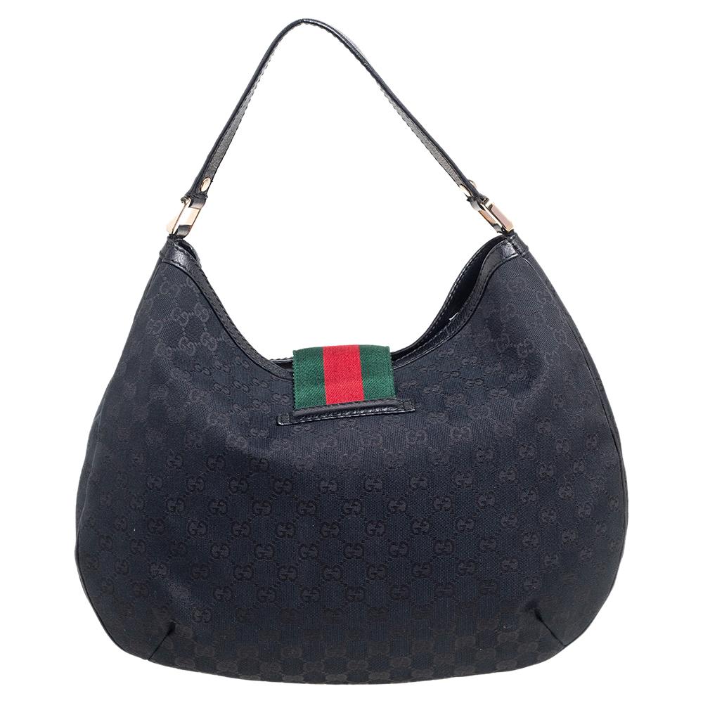 Crafted from GG canvas and leather in Italy, this gorgeous bag from Gucci is a design that has never gone out of style. It has a flap styled as their iconic Web stripe, and it opens up to a spacious canvas interior. Held by a single leather handle,