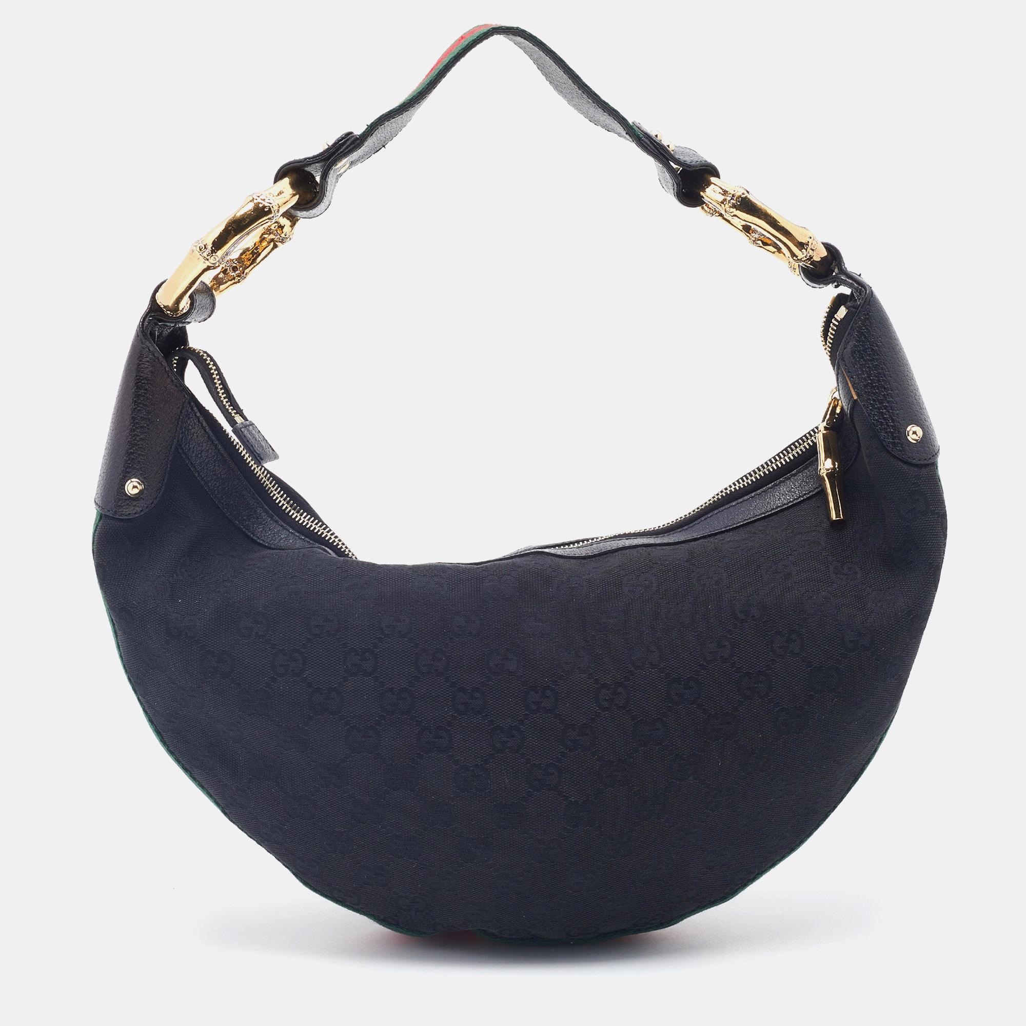 This stunning Bamboo Ring hobo comes from the House of Gucci. It has been crafted from black GG canvas and leather on the exterior. It features a single handle, a fabric-lined interior, and gold-toned hardware. Make this stunning Gucci hobo yours